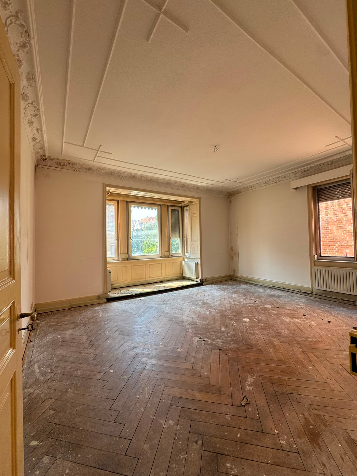 Nachher: leergeräumtes Altbau-Wohnzimmer mit freiem Fischgrätparkett nach der Entrümpelung durch DEK Räumungsdienst