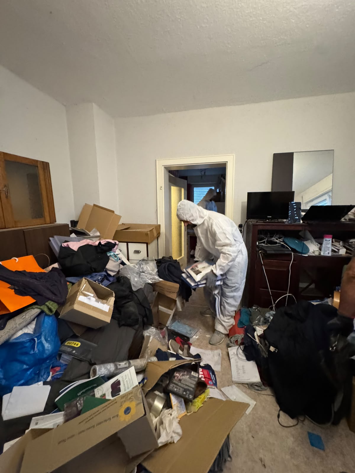 Mitarbeiter sortiert Unterlagen und Wertsachen bei einer Entrümpelung