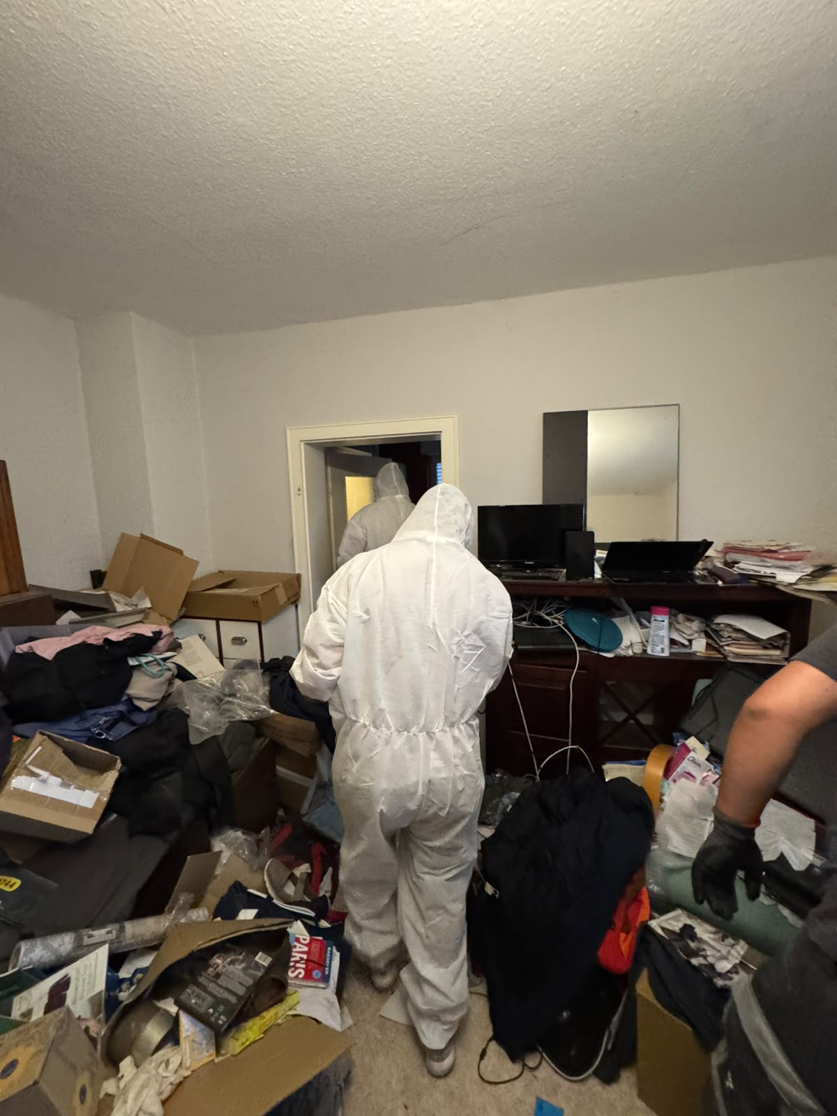 DEK Mitarbeiter in Schutzanzügen bei der Räumung einer Messie-Wohnung