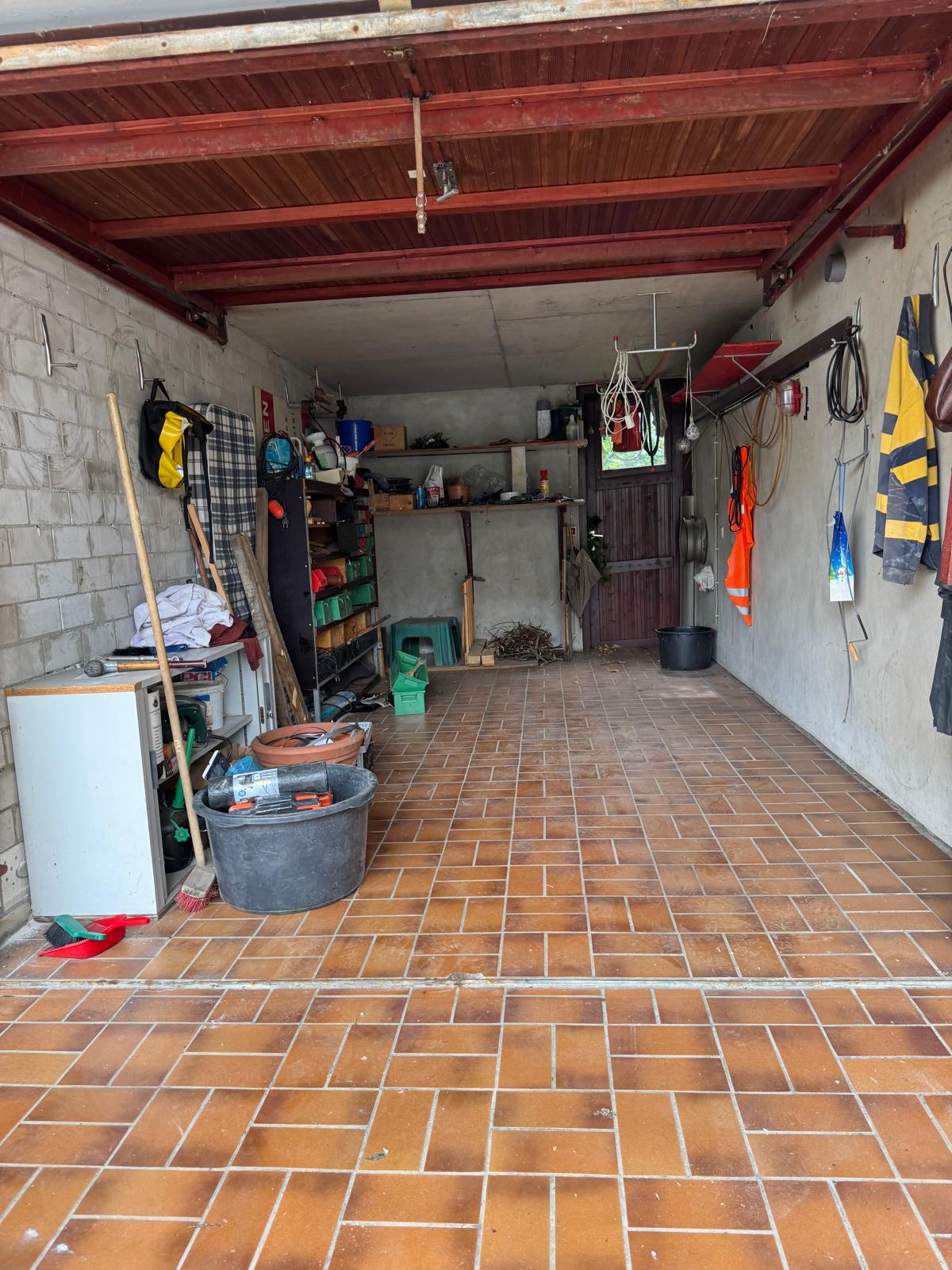 Vorher: volle Garage mit Regalen, Werkzeug und Sperrgut vor der Räumung